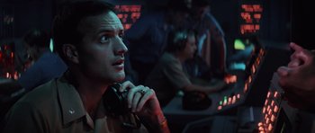 Movie still from “The Hunt for Red October” (1990), directed by John McTiernan – A man sitting at a table in front of a computer; Close Up shot, Low angle