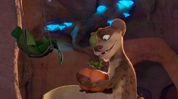 Movie still from “The Ice Age Adventures of Buck Wild” (2022), directed by John C. Donkin – A bear holding an orange in his mouth; Medium shot, Overhead angle