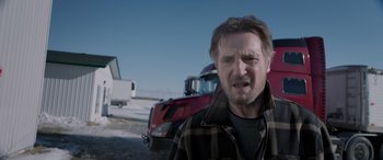 Movie still from “The Ice Road” (2021), directed by Jonathan Hensleigh – A person standing near a red truck; Close Up shot, Low angle