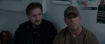 Movie still from “The Ice Road” (2021), directed by Jonathan Hensleigh – Two men sitting next to each other in front of a window; Medium shot, Over the shoulder angle