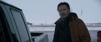 Movie still from “The Ice Road” (2021), directed by Jonathan Hensleigh – A man standing in front of a truck in the snow; Medium shot, Over the shoulder angle