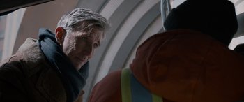 Movie still from “The Ice Road” (2021), directed by Jonathan Hensleigh – An older man looking at something in the distance; Close Up shot, Over the shoulder angle