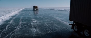 Movie still from “The Ice Road” (2021), directed by Jonathan Hensleigh – A semi truck driving on the ice of a frozen lake; Extreme Wide shot, High angle