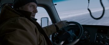 Movie still from “The Ice Road” (2021), directed by Jonathan Hensleigh – A man driving a truck in the snow; Medium shot, High angle