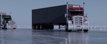 Movie still from “The Ice Road” (2021), directed by Jonathan Hensleigh – A semi truck driving down the road in the snow; Extreme Wide shot, Low angle