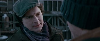 Movie still from “The Ice Road” (2021), directed by Jonathan Hensleigh – A man in a hat and a jacket looking to his left; Close Up shot, Over the shoulder angle