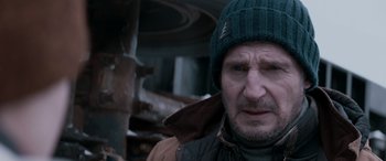 Movie still from “The Ice Road” (2021), directed by Jonathan Hensleigh – A person wearing a jacket and a hat; Close Up shot, Over the shoulder angle