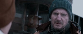Movie still from “The Ice Road” (2021), directed by Jonathan Hensleigh – A person wearing a jacket and a hat; Close Up shot, Over the shoulder angle