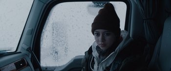 Movie still from “The Ice Road” (2021), directed by Jonathan Hensleigh – A woman with a hat looking out of a car window; Close Up shot, Over the shoulder angle