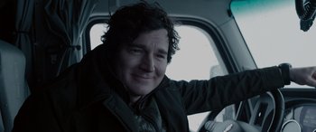 Movie still from “The Ice Road” (2021), directed by Jonathan Hensleigh – A man with curly hair sitting in a car; Close Up shot, Over the shoulder angle
