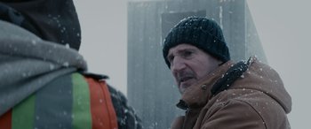 Movie still from “The Ice Road” (2021), directed by Jonathan Hensleigh – A person wearing a jacket and a hat; Close Up shot, Over the shoulder angle