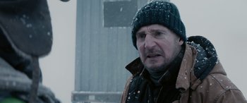 Movie still from “The Ice Road” (2021), directed by Jonathan Hensleigh – A person wearing a jacket and a hat; Close Up shot, Over the shoulder angle