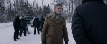 Movie still from “The Ice Road” (2021), directed by Jonathan Hensleigh – An older man wearing a brown coat in the snow; Medium shot, Over the shoulder angle