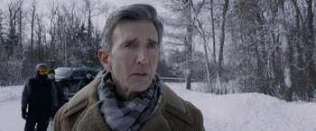 Movie still from “The Ice Road” (2021), directed by Jonathan Hensleigh – An older man wearing a scarf in the snow; Close Up shot, Over the shoulder angle