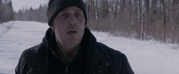 Movie still from “The Ice Road” (2021), directed by Jonathan Hensleigh – A person wearing a jacket and a hat; Close Up shot, Over the shoulder angle