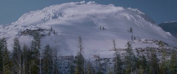 Movie still from “The Ice Road” (2021), directed by Jonathan Hensleigh – A snowy mountain with trees in the foreground; Extreme Wide shot, Low angle