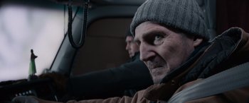 Movie still from “The Ice Road” (2021), directed by Jonathan Hensleigh – A man with a beard and a hat in the back of a car; Close Up shot, Over the shoulder angle