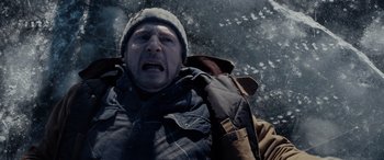 Movie still from “The Ice Road” (2021), directed by Jonathan Hensleigh – A man in a winter coat and hat is crying; Close Up shot, High angle