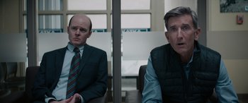 Movie still from “The Ice Road” (2021), directed by Jonathan Hensleigh – Two men sitting next to each other in a room; Medium shot, Over the shoulder angle