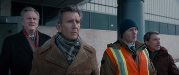 Movie still from “The Ice Road” (2021), directed by Jonathan Hensleigh – A man wearing a coat and a scarf; Medium shot, Over the shoulder angle