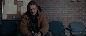 Movie still from “The Ice Road” (2021), directed by Jonathan Hensleigh – A man with a bandage on his face sitting on a chair; Medium shot, Over the shoulder angle