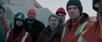 Movie still from “The Ice Road” (2021), directed by Jonathan Hensleigh – A group of men standing next to each other; Medium shot, Low angle