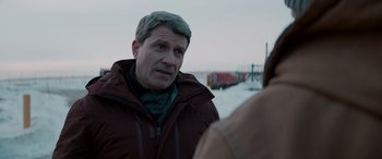 Movie still from “The Ice Road” (2021), directed by Jonathan Hensleigh – A man in a red jacket talking to a woman; Medium shot, Over the shoulder angle