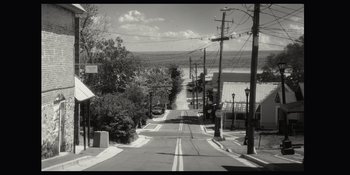 Movie still from “The In Between” (2022), directed by Arie Posin – An empty street with power lines on both sides of the street; Extreme Wide shot, High angle