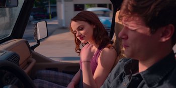 Movie still from “The In Between” (2022), directed by Arie Posin – A woman sitting in the passenger seat of a car; Medium shot, Over the shoulder angle