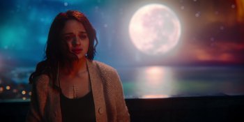 Movie still from “The In Between” (2022), directed by Arie Posin – A woman standing in front of a moon lit sky; Medium shot, Over the shoulder angle