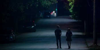 Movie still from “The In Between” (2022), directed by Arie Posin – Two people standing on the side of the road at night; Wide shot, High angle