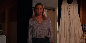 Movie still from “The In Between” (2022), directed by Arie Posin – A woman standing in front of a curtain; Medium shot, Over the shoulder angle