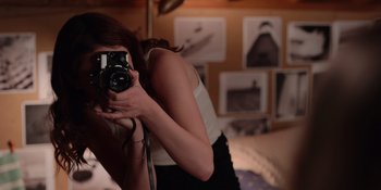 Movie still from “The In Between” (2022), directed by Arie Posin – A woman taking a picture of herself in the mirror; Medium shot, Over the shoulder angle