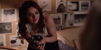 Movie still from “The In Between” (2022), directed by Arie Posin – A beautiful young lady holding a camera in a living room; Close Up shot, High angle