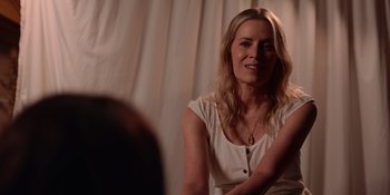 Movie still from “The In Between” (2022), directed by Arie Posin – A woman sitting in front of a white curtain; Close Up shot, Over the shoulder angle