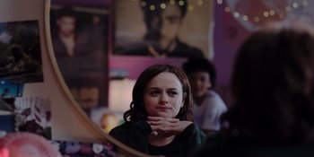Movie still from “The In Between” (2022), directed by Arie Posin – A woman sitting in front of a mirror in a room; Close Up shot, Over the shoulder angle