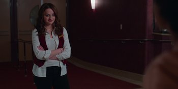 Movie still from “The In Between” (2022), directed by Arie Posin – A woman standing in a hallway with her arms crossed; Medium shot, Over the shoulder angle