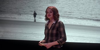 Movie still from “The In Between” (2022), directed by Arie Posin – A woman standing in front of the ocean holding a cell phone; Medium shot, Over the shoulder angle