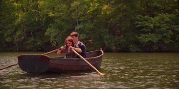 Movie still from “The In Between” (2022), directed by Arie Posin – A man and a woman are in a boat on the water; Wide shot, High angle