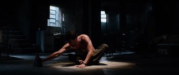 Movie still from “The Incredible Hulk” (2008), directed by Louis Leterrier – A man is doing a yoga pose on the floor; Wide shot, High angle