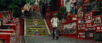 Movie still from “The Incredible Hulk” (2008), directed by Louis Leterrier – A man walking down a street near a set of stairs; Wide shot, High angle