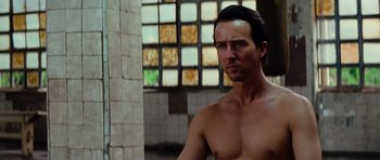 Movie still from “The Incredible Hulk” (2008), directed by Louis Leterrier – A shirtless man in front of a wall of stained glass windows; Close Up shot, Low angle