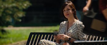 Movie still from “The Incredible Hulk” (2008), directed by Louis Leterrier – A woman sitting on top of a park bench while holding a cell phone; Medium shot, Over the shoulder angle