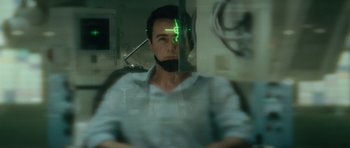 Movie still from “The Incredible Hulk” (2008), directed by Louis Leterrier – A man in a white shirt with a green light on his face; Close Up shot, Over the shoulder angle