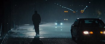 Movie still from “The Incredible Hulk” (2008), directed by Louis Leterrier – A man standing in the middle of the road in the rain; Wide shot, Over the shoulder angle
