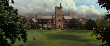 Movie still from “The Incredible Hulk” (2008), directed by Louis Leterrier – A man walking across a lush green field near a large building; Extreme Wide shot, High angle