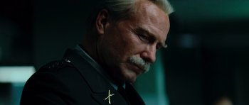 Movie still from “The Incredible Hulk” (2008), directed by Louis Leterrier – An older man wearing a suit with a cross on it; Close Up shot, Low angle