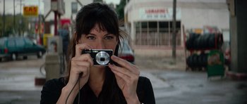 Movie still from “The Incredible Hulk” (2008), directed by Louis Leterrier – A woman taking a picture with a camera; Close Up shot, Low angle