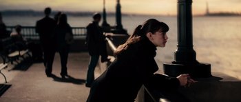 Movie still from “The Incredible Hulk” (2008), directed by Louis Leterrier – A woman standing next to a railing near a body of water; Medium shot, Over the shoulder angle