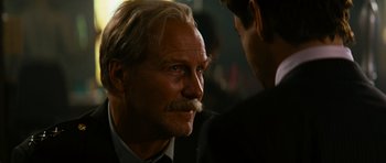 Movie still from “The Incredible Hulk” (2008), directed by Louis Leterrier – An older man with a mustache talking to a younger man; Close Up shot, Over the shoulder angle